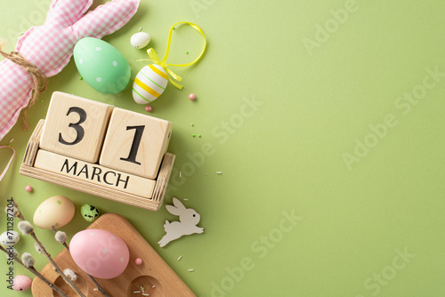 Counting Down to Easter Bliss: Top view of lively eggs in container, charming bunny, date on wooden blocks, pussy willow, sugar sprinkles on pastel green. Advertise your Easter joy here