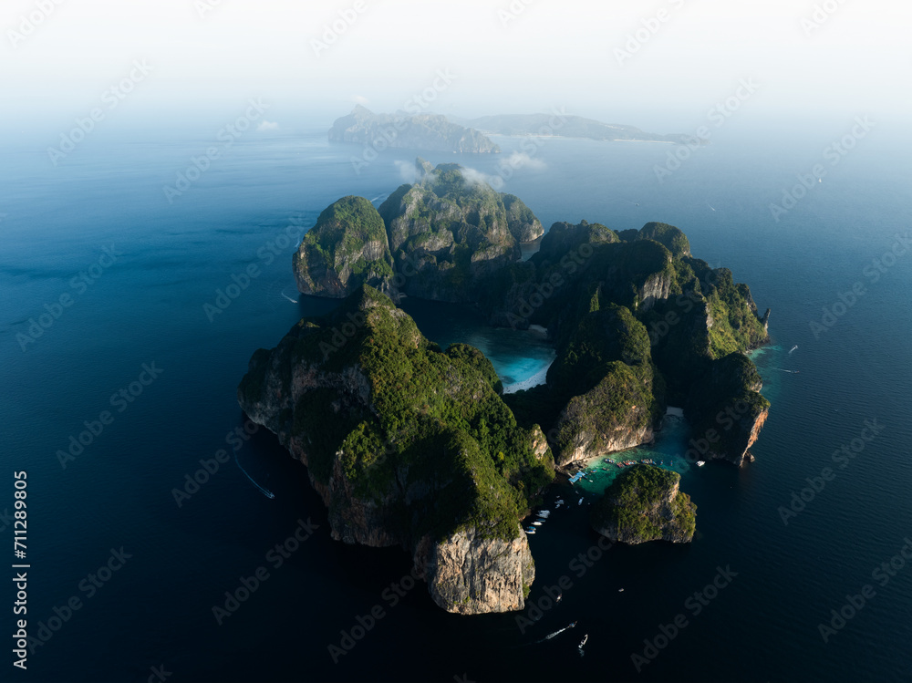 Stunning aerial view of Ko Phi Phi Lee, a ring of steep limestone hills surrounding Maya Bay with Phi Phi Don in the distance. Phi Phi Islands, Andaman Sea, Krabi, Thailand.