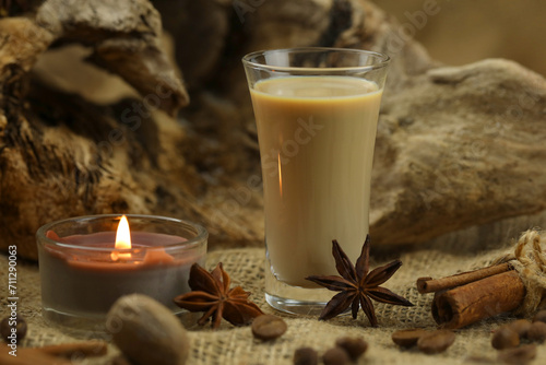 Glass of irish cream liqueur with spice. Cloth background with copy space