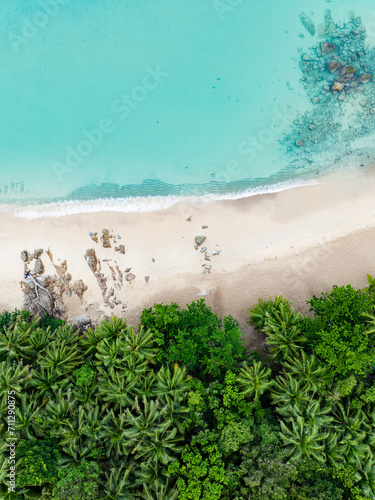 Obraz na płótnie View from above, stunning aerial view of Banana beach, a beautiful white sand beach surrounded by palm trees and bathed by a turquoise water. Phuket, Thailand. w salonie