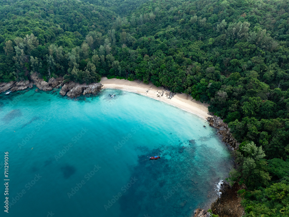 View from above, stunning aerial view of Banana beach, a beautiful white sand beach surrounded by palm trees and bathed by a turquoise water. Phuket, Thailand.