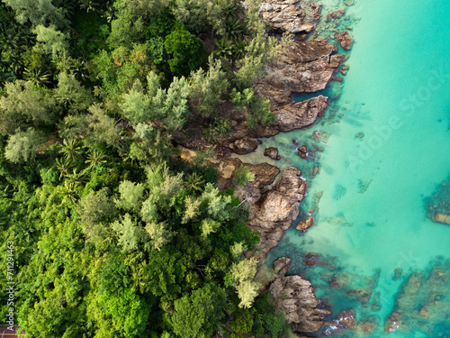 Obraz na płótnie View from above, stunning aerial view of a rocky coastline surrounded by palm trees and bathed by a turquoise water. Phuket, Thailand. w salonie