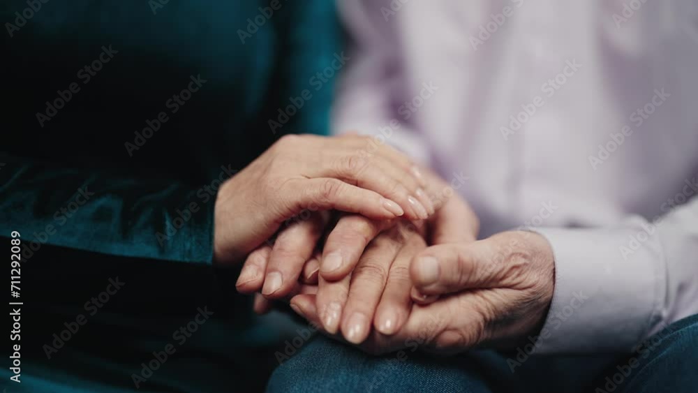 Senior woman stroking man hands. Tender gentle elderly wife supporting husband caring in stress situation, hands close-up. Old family couple holding hands. Care love support lifelong concept. Senior woman stroking man hands. Tender gentle elderly wife supporting husband caring in stress situation, hands close-up. Old family couple holding hands. Care love support lifelong concept.