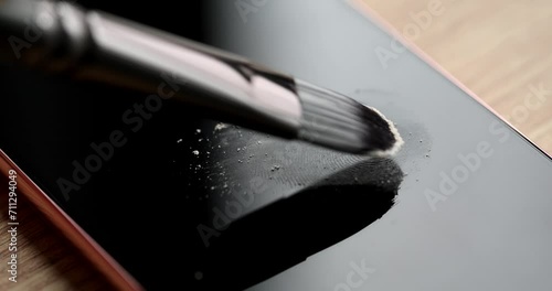 Forensic expert brushing talcum powder on fingerprint on mobile phone screen closeup 4k movie slow motion. Traces of crime disclosure of criminal cases concept photo