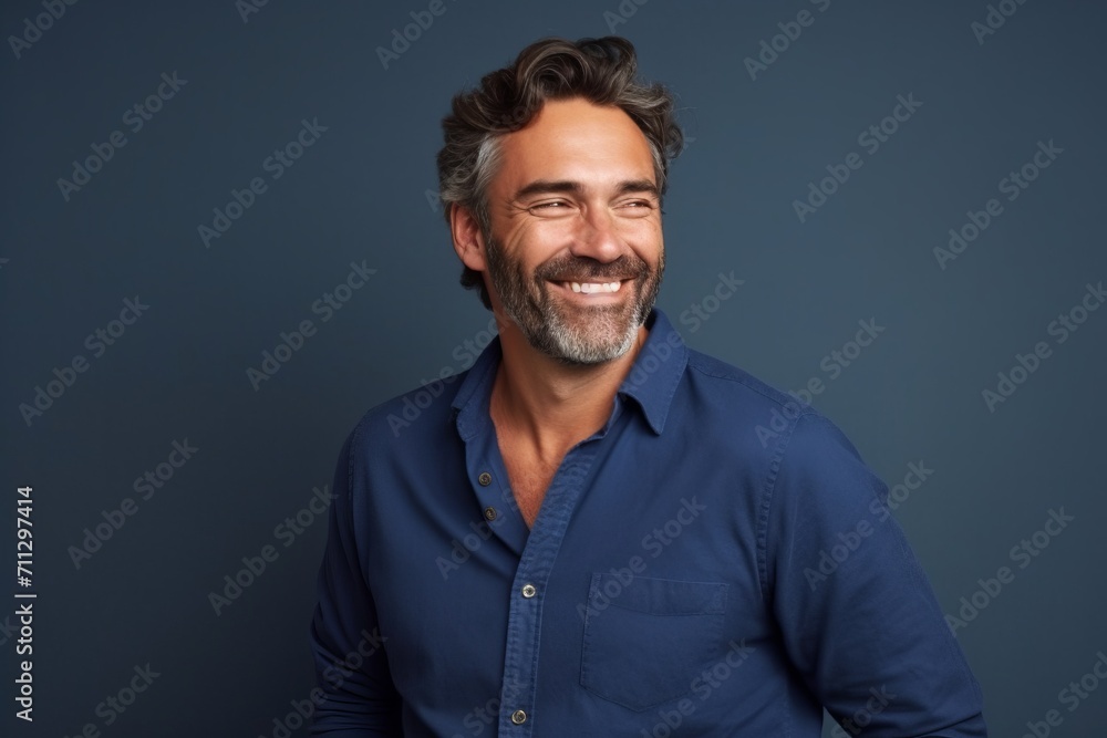 Portrait of a handsome middle-aged man smiling against blue background Portrait of a handsome middle-aged man smiling against blue background