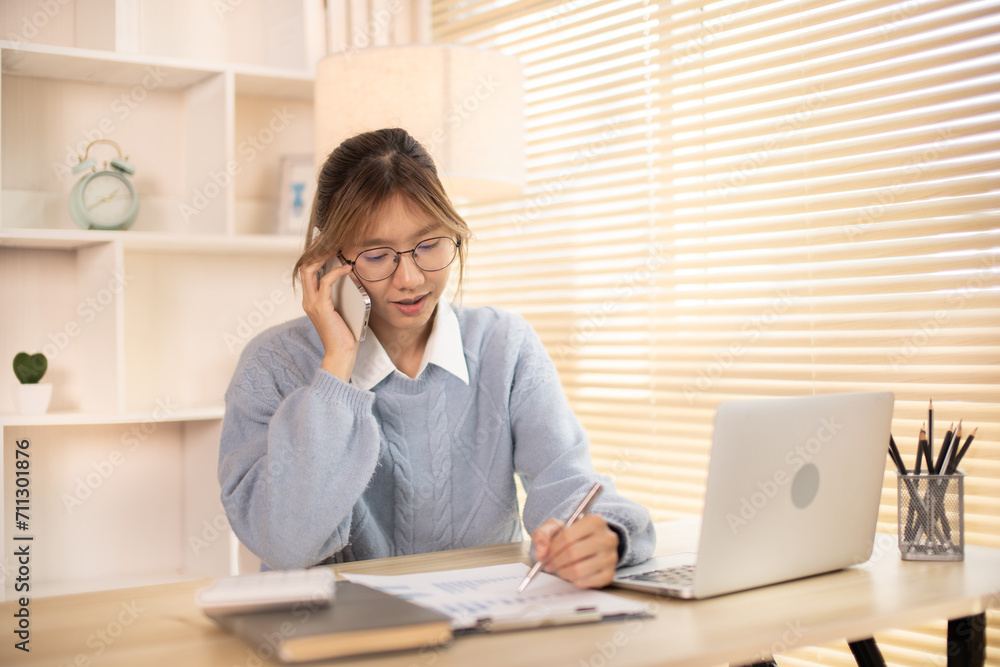 Woman Multitasking: Take note, Talking on Phone at Home Office , Home Workspace, Woman busy with work in office, Working in front of a laptop. Woman Multitasking: Take note, Talking on Phone at Home Office , Home Workspace, Woman busy with work in office, Working in front of a laptop.