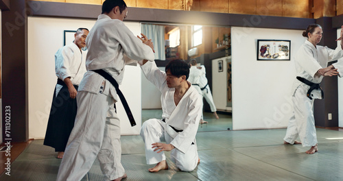 Martial arts, sensei and Japanese students with training, fitness and action in class for defence or technique. Aikido, people or fighting with discipline, uniform or confidence for culture and skill