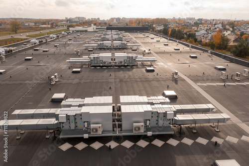 Drone photography of large commercial building rooftop with air conditioning machinery during autumn morning