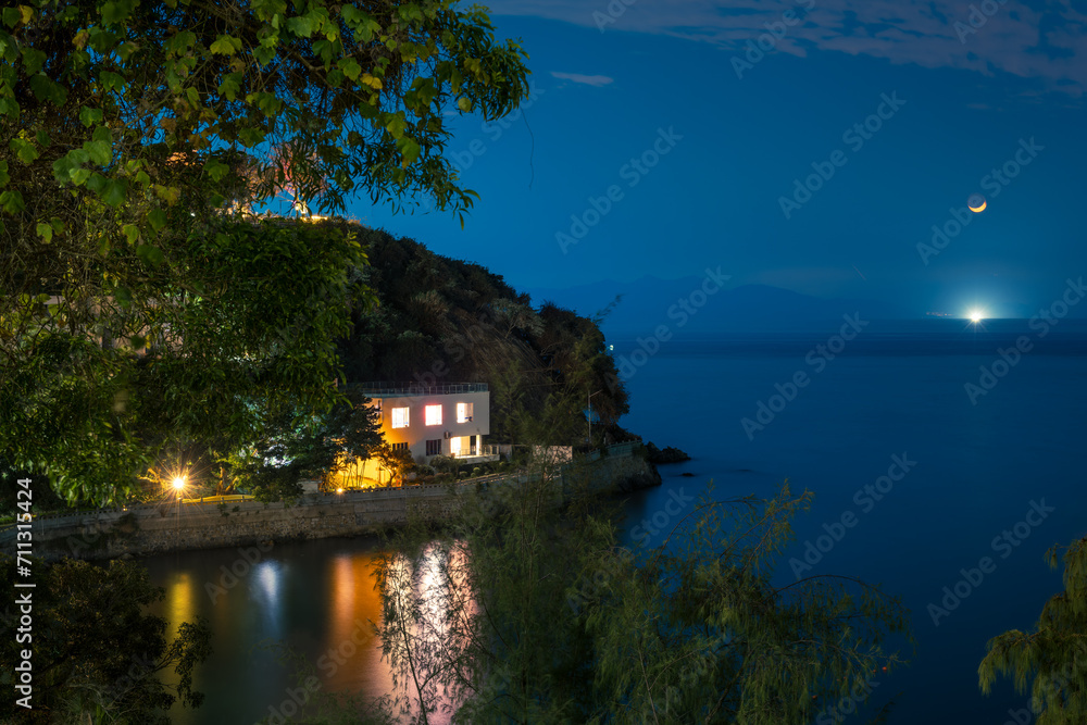 landscape of mountains, house and ocean in moon night