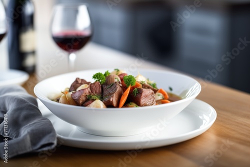 beef bourguignon plated on fine china with red wine