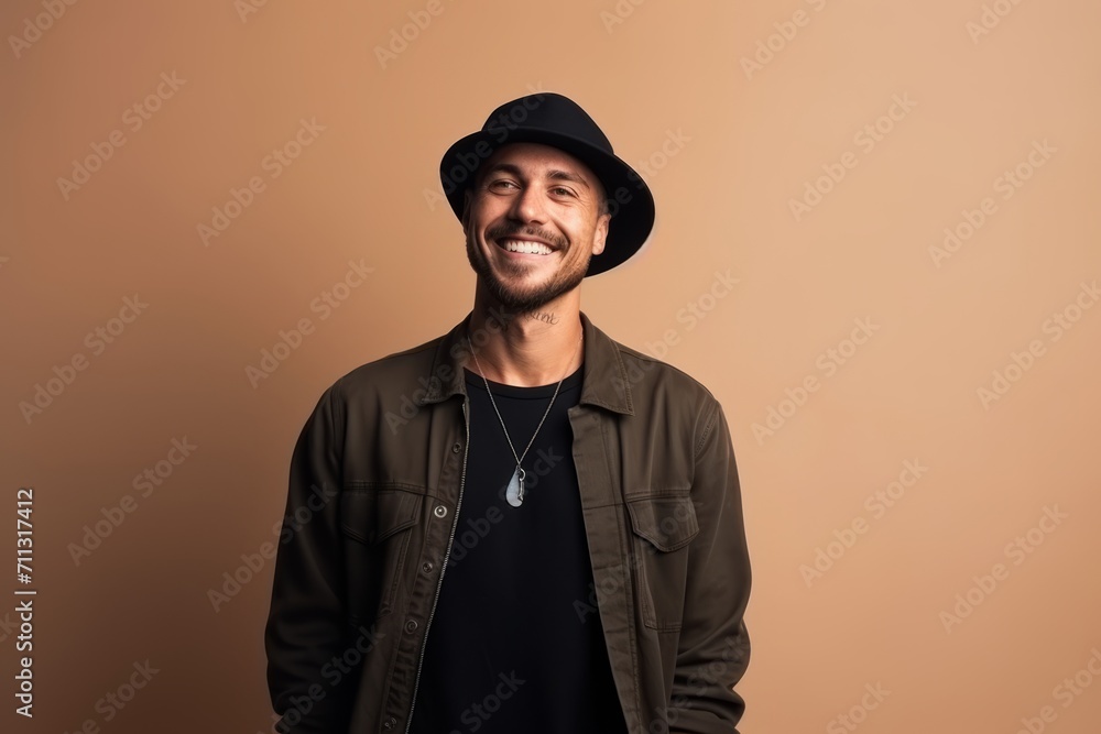 Handsome man wearing a hat and jacket on a brown background Handsome man wearing a hat and jacket on a brown background