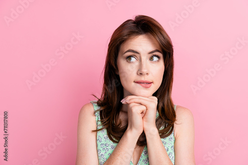 Photo of adorable girl wear stylish clothes arm touch face look up interesting information empty space isolated on pink color background