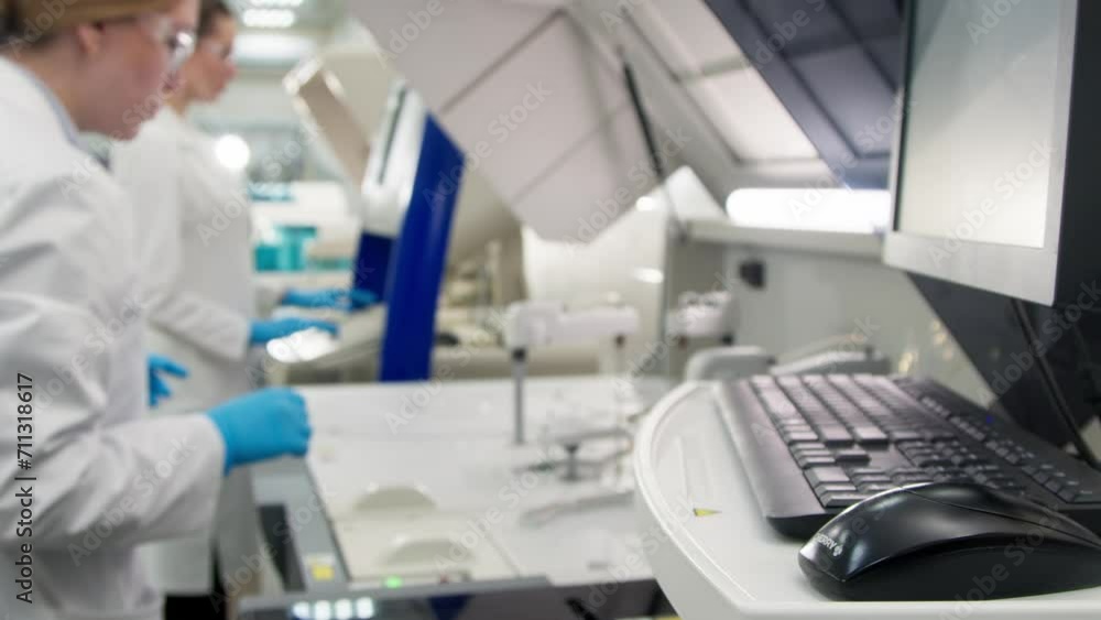 A medical research laboratory with a diverse team of biochemical scientists working with computers and modern medical technologies. Development of high-tech equipment for medicines. A medical research laboratory with a diverse team of biochemical scientists working with computers and modern medical technologies. Development of high-tech equipment for medicines.