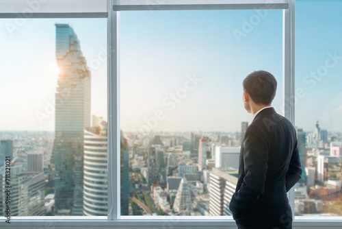 A businessman is observing the future metropolis from the top of an office tower. © chartphoto