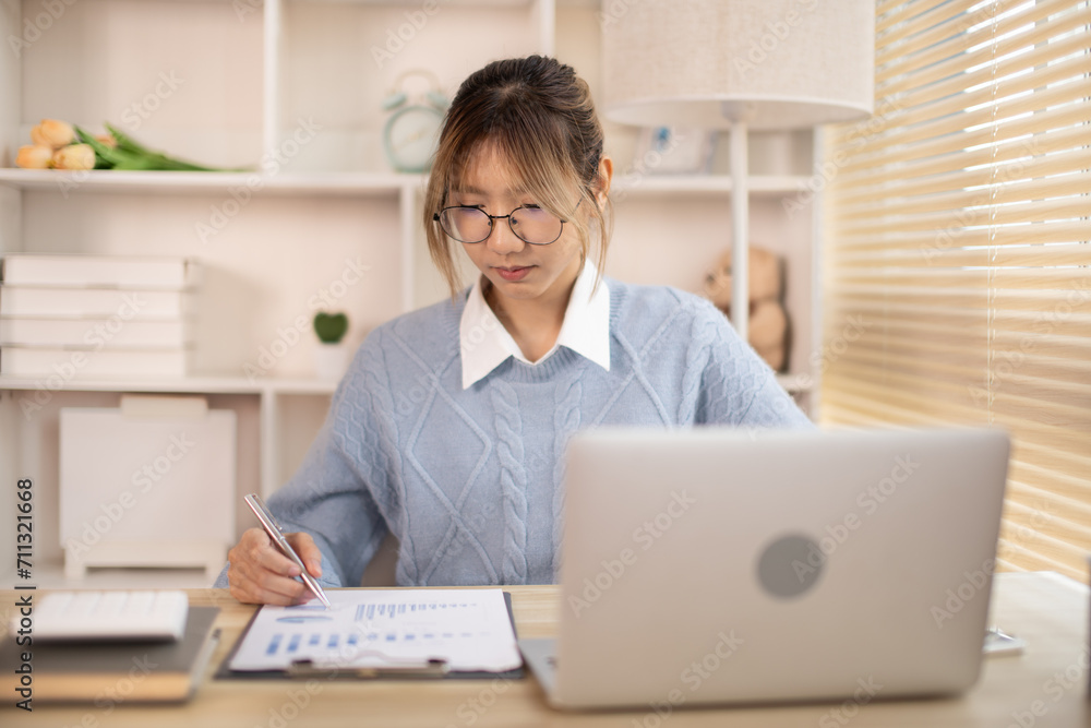 Woman analyzes data graphs, Works intently in his personal office, Employees working in the office, Businesswoman working in front of laptop. Woman analyzes data graphs, Works intently in his personal office, Employees working in the office, Businesswoman working in front of laptop.