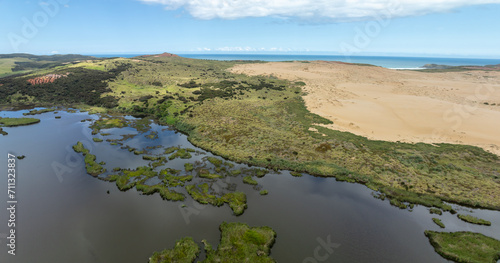 Fototapeta Naklejka Na Ścianę i Meble -  Aerial: Lake, farmland and sand dunes in Cape Reinga, Northland, New Zealand.