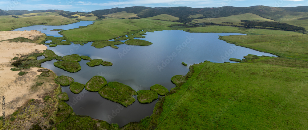 Aerial: Lake, farmland and sand dunes in Cape Reinga, Northland, New Zealand.