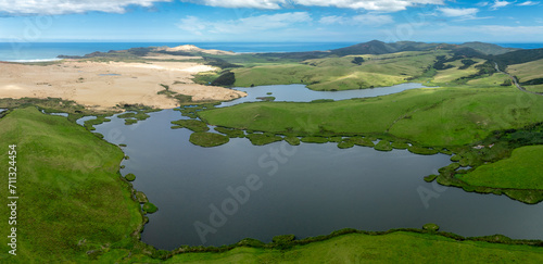 Aerial: Lake, farmland and sand dunes in Cape Reinga, Northland, New Zealand.