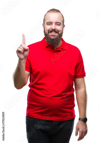 Young caucasian hipster man wearing red shirt over isolated background showing and pointing up with finger number one while smiling confident and happy.