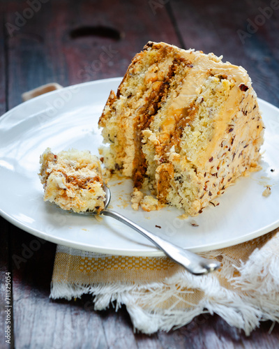 Slice Caramel Nut Cake. Crumbled natural nuts soaked in caramel filling. Its topping on the cake is spread with caramel whipped cream  and cream cheese and roasted diced nuts.