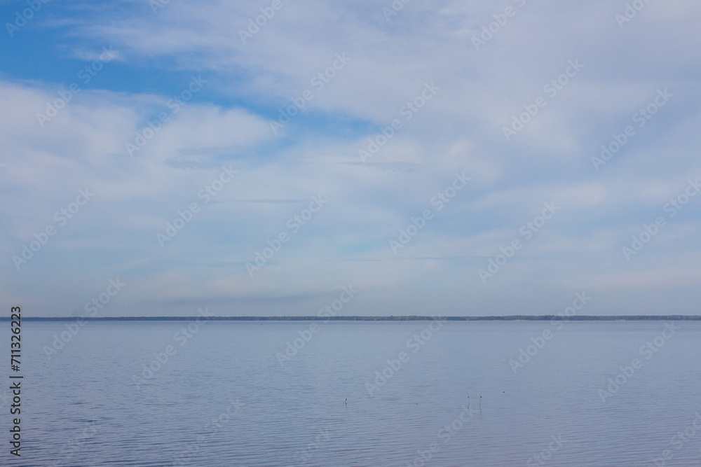 Blue sky with white clouds over the water surface. Nature background. Dnipro river. Ukraine