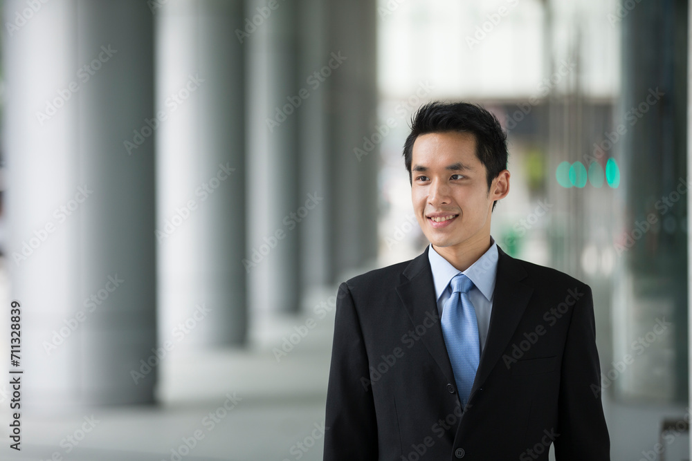 happy young Chinese business man in modern city