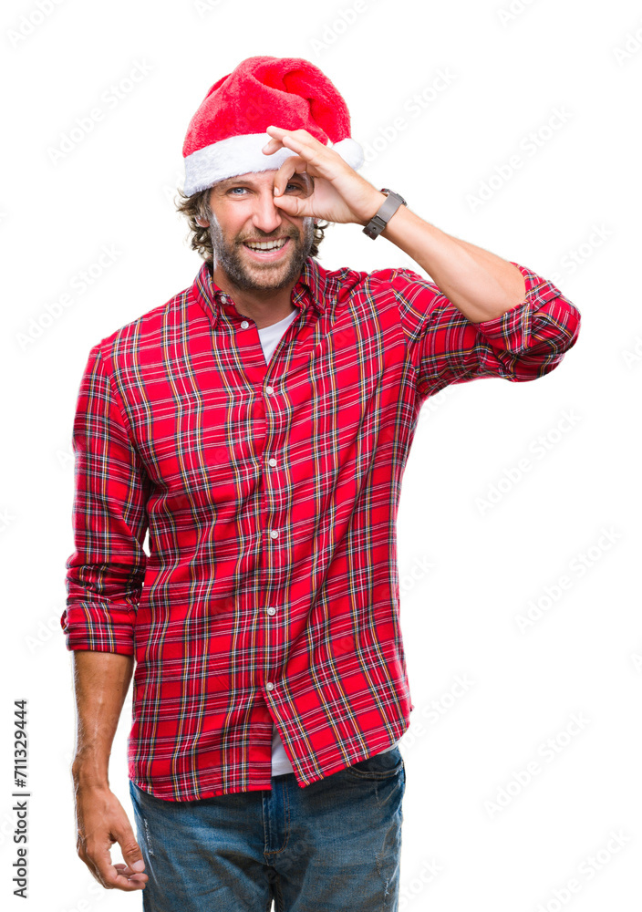 Handsome hispanic man model wearing santa claus christmas over isolated background doing ok gesture with hand smiling, eye looking through fingers with happy face. Handsome hispanic man model wearing santa claus christmas over isolated background doing ok gesture with hand smiling, eye looking through fingers with happy face.