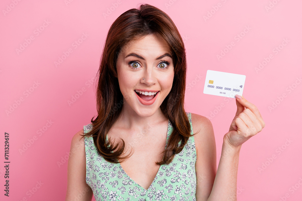 Photo of lovely nice girl wear stylish print clothes hold bank card recommend easy pay isolated on pink color background Photo of lovely nice girl wear stylish print clothes hold bank card recommend easy pay isolated on pink color background