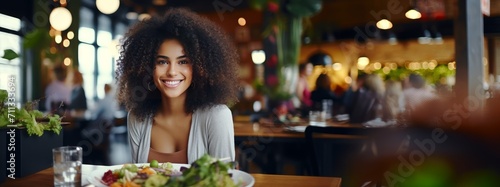 African American woman eating healthy food in a restaurant photo