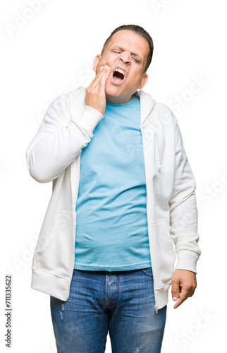Middle age arab man wearing sweatshirt over isolated background touching mouth with hand with painful expression because of toothache or dental illness on teeth. Dentist concept.