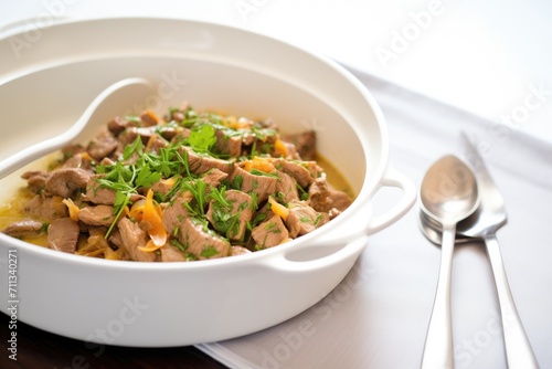 steaming beef stroganoff in a white ceramic dish with a spoon