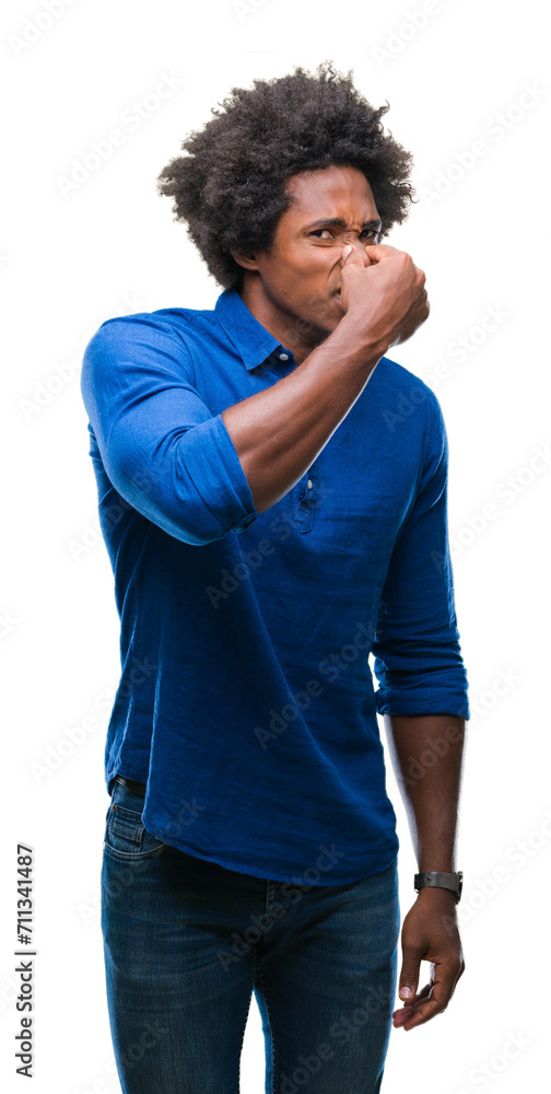 Afro american man over isolated background smelling something stinky and disgusting, intolerable smell, holding breath with fingers on nose. Bad smells concept. Afro american man over isolated background smelling something stinky and disgusting, intolerable smell, holding breath with fingers on nose. Bad smells concept.