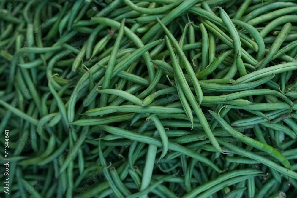 Heap of fresh, vibrant green beans arranged neatly on a countertop Heap of fresh, vibrant green beans arranged neatly on a countertop