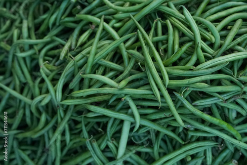 Heap of fresh, vibrant green beans arranged neatly on a countertop