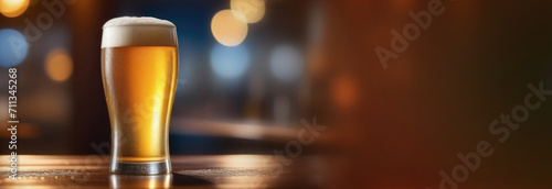 A glass of beer on a dark blurred background. Beer place for text photo