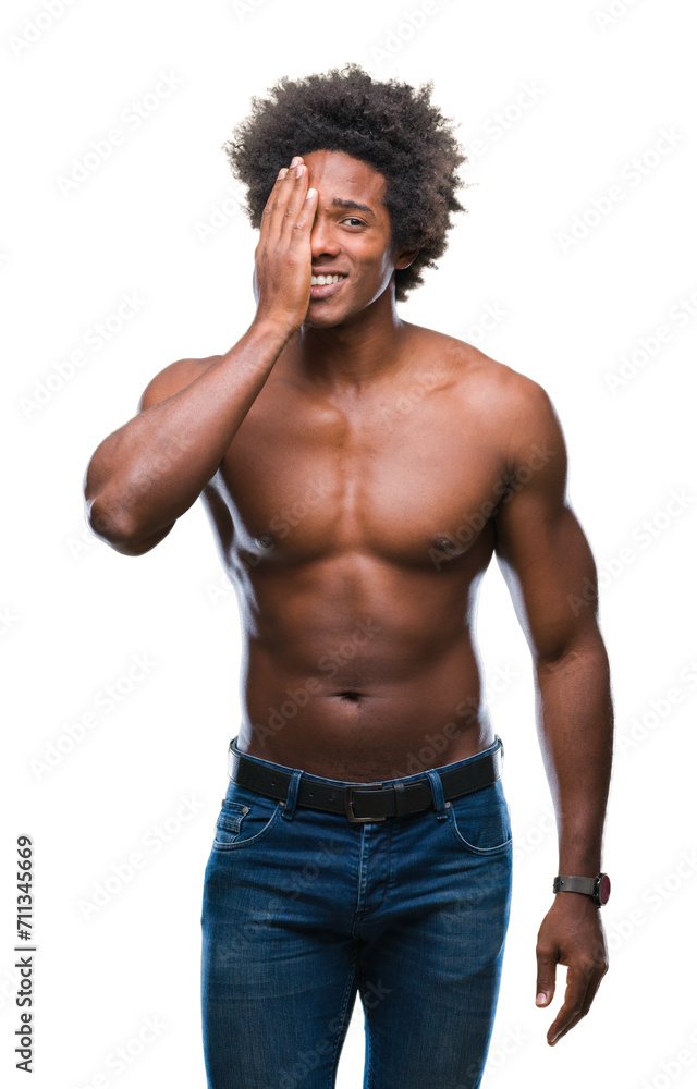 Afro american shirtless man showing nude body over isolated background covering one eye with hand with confident smile on face and surprise emotion.