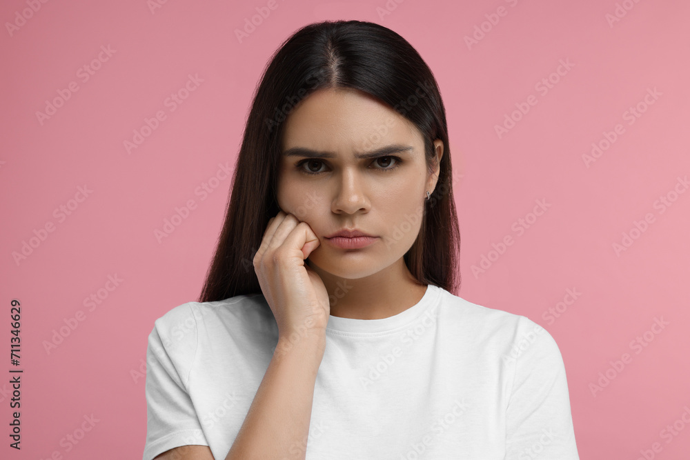 Portrait of resentful woman on pink background Portrait of resentful woman on pink background
