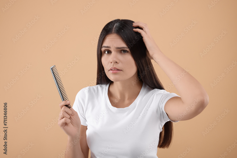 Emotional woman with comb examining her hair and scalp on beige background. Dandruff problem Emotional woman with comb examining her hair and scalp on beige background. Dandruff problem