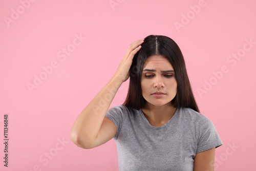 Emotional woman examining her hair and scalp on pink background, space for text. Dandruff problem © New Africa