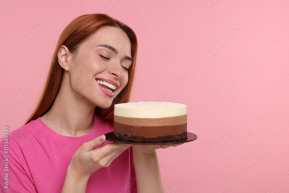 Young woman with tasty cake on pink background Young woman with tasty cake on pink background