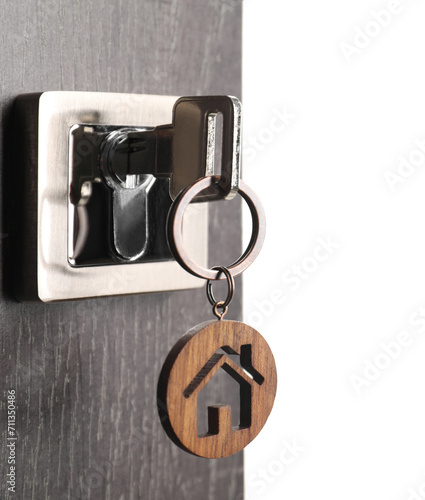 Mortgage and real estate. Open door with key and house shaped keychain on white background, space for text
