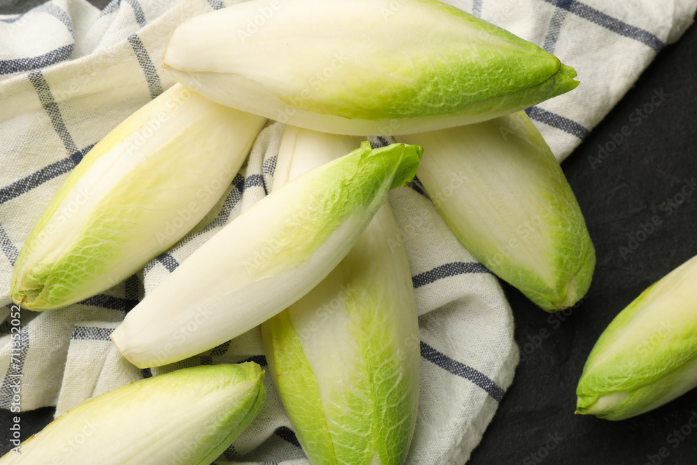 Fresh raw Belgian endives (chicory) on black table, top view Fresh raw Belgian endives (chicory) on black table, top view