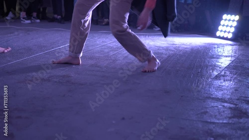 Contemporary or modern choreography. Women dancing barefoot on the concrete floor. Theatrical production of an art house about a modern fast fashion. Bare feet on the cold floor. photo