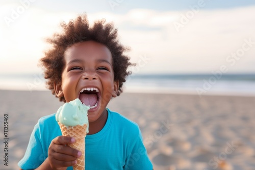 Cute african american boy holding an ice cream on the beach in summer. Kid with gelato concept with copy space