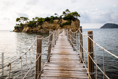 wooden footbridge leading to the small island of Agios Sostis on Zakynthos, Greece, during a sunny summer day © Melinda Nagy