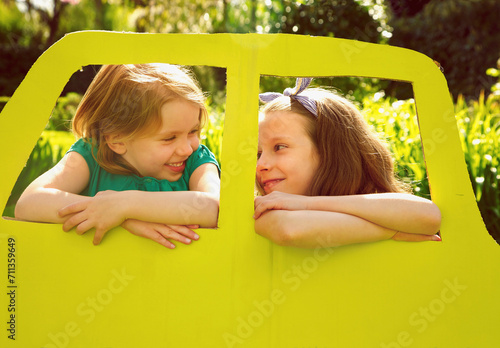 Young Girls Leaning out of Cardboard Car Window
 photo