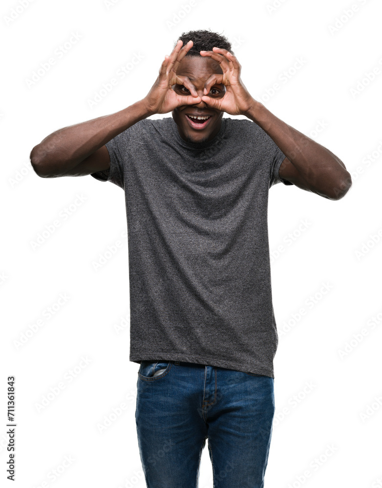 Fototapeta premium Young african american man wearing grey t-shirt doing ok gesture like binoculars sticking tongue out, eyes looking through fingers. Crazy expression.