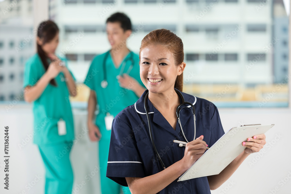 Nurse standing in a hospital with her team Nurse standing in a hospital with her team