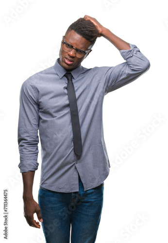 Young african american business man over isolated background confuse and wonder about question. Uncertain with doubt, thinking with hand on head. Pensive concept.