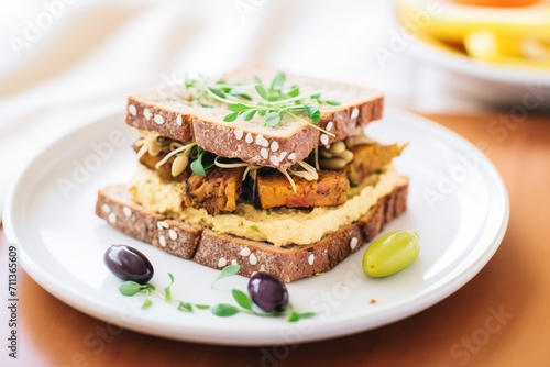 mediterranean tempeh sandwich with hummus and olives